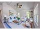 Bright living room featuring vaulted ceiling, large windows, plush white sofa, and stylish decor, creating a comfortable and inviting space at 11401 2Nd Ave, Punta Gorda, FL 33955