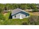 A rear exterior view of the home surrounded by lush greenery and blue skies at 11401 2Nd Ave, Punta Gorda, FL 33955