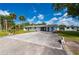 Exterior view of the property highlighting the lush landscaping, expansive driveway, and overall setting at 1214 Ansin St, Punta Gorda, FL 33950