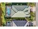 Aerial view of property showcasing roof, pool, screened lanai, and tropical landscaping at 13056 N Marsh Dr, Port Charlotte, FL 33953