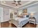 Comfortable bedroom with wooden floors features a ceiling fan, queen bed, and plenty of natural light at 13056 N Marsh Dr, Port Charlotte, FL 33953