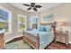 Charming bedroom with a carved wooden bed, leaf ceiling fan, and bright natural light at 13056 N Marsh Dr, Port Charlotte, FL 33953