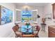 Cozy dining area features a glass table, four wicker chairs, and views of the pool through shuttered windows at 13056 N Marsh Dr, Port Charlotte, FL 33953