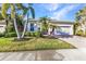 Well-maintained exterior with lush landscaping, palm trees, and a paved driveway at 13056 N Marsh Dr, Port Charlotte, FL 33953