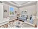 Bright office with a tray ceiling, desk, seating, and beach-themed artwork at 13056 N Marsh Dr, Port Charlotte, FL 33953