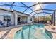 This screened in pool features outdoor dining and lounging and a beautiful water feature at 13056 N Marsh Dr, Port Charlotte, FL 33953