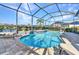 Screened pool with brick surround, water feature, and view of the surrounding landscaping and neighborhood at 13056 N Marsh Dr, Port Charlotte, FL 33953