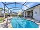 Enclosed pool with patio, dining area, and view of tropical landscaping with palm trees and neighborhood at 13056 N Marsh Dr, Port Charlotte, FL 33953