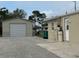 Backyard featuring a detached garage, a partial view of home and gravel driveway at 137 Revere Nw St, Port Charlotte, FL 33952