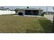 Large backyard featuring grass and an enclosed patio area at 137 Revere Nw St, Port Charlotte, FL 33952