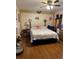 Cozy bedroom with hardwood floors, a ceiling fan, and unique decorative wall hangings at 137 Revere Nw St, Port Charlotte, FL 33952