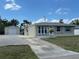 Charming single-story home with a well-maintained lawn, a long driveway, and a detached garage at 137 Revere Nw St, Port Charlotte, FL 33952