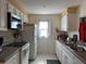 Well-lit kitchen featuring white cabinetry, a built-in microwave, and plenty of counter workspace at 137 Revere Nw St, Port Charlotte, FL 33952