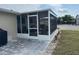 Enclosed porch featuring a tile patio, a dining area with a grill, and a well-kept lawn at 137 Revere Nw St, Port Charlotte, FL 33952