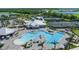 Aerial view of the community pool, tennis courts, clubhouse, and surrounding lush landscaping at 14049 Black Beauty Dr # 721, Punta Gorda, FL 33955