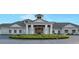 A grand clubhouse entrance features detailed trim, pillars, and colorful flowerbeds in front at 14049 Black Beauty Dr # 721, Punta Gorda, FL 33955