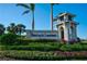 Well-maintained community entrance sign with lush landscaping and towering palm trees on a sunny day at 14049 Black Beauty Dr # 721, Punta Gorda, FL 33955