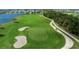 Scenic golf course view with sand traps, lush greenery, golf carts and waterfront in the background at 14049 Black Beauty Dr # 721, Punta Gorda, FL 33955