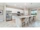 Bright kitchen featuring white cabinets, a stainless steel refrigerator, and a granite-topped island with seating at 14049 Black Beauty Dr # 721, Punta Gorda, FL 33955