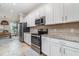 Modern kitchen with white cabinets, stainless steel appliances, and granite countertops, adjacent to the dining area at 14049 Black Beauty Dr # 721, Punta Gorda, FL 33955