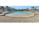 Zero entry community pool area surrounded by ample lounge chairs and palm trees for relaxing by the water at 14049 Black Beauty Dr # 721, Punta Gorda, FL 33955