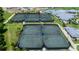 Aerial view of multiple meticulously maintained tennis courts with shade structures, ready for a match at 14049 Black Beauty Dr # 721, Punta Gorda, FL 33955