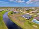 An aerial view showcasing canal-front home with a well-maintained yard in nice neighborhood at 149 Sportsman Rd, Rotonda West, FL 33947