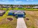 Charming single-story blue home featuring a gray roof, well-maintained landscaping, and a spacious driveway at 149 Sportsman Rd, Rotonda West, FL 33947