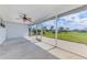 Screened-in patio with a ceiling fan and a view of the lush green lawn and mature trees at 149 Sportsman Rd, Rotonda West, FL 33947