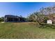 Spacious backyard showing a pool enclosure, shed, and expansive lawn area at 156 Danforth Dr, Punta Gorda, FL 33980