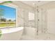 Bright bathroom featuring a modern tub under a large window, alongside a frameless glass shower at 16210 Cape Horn Blvd, Punta Gorda, FL 33955