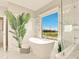 Serene bathroom boasts a freestanding tub with picturesque views and a lush tropical plant at 16210 Cape Horn Blvd, Punta Gorda, FL 33955