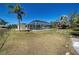 Spacious backyard featuring a screened-in pool and mature palm trees, perfect for outdoor activities and relaxation at 165 Cummins Ne Ave, Port Charlotte, FL 33952