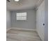 This bedroom features light gray walls, a window for natural light, and a spacious closet with white doors at 165 Cummins Ne Ave, Port Charlotte, FL 33952