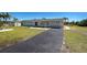 Charming single-story home featuring a well-manicured lawn and long, paved driveway leading up to the entrance at 165 Cummins Ne Ave, Port Charlotte, FL 33952