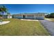 Charming home with a well-maintained lawn, tasteful landscaping, and a welcoming entrance at 165 Cummins Ne Ave, Port Charlotte, FL 33952