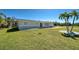 A charming home with a lush green lawn and beautiful palm tree landscaping at 165 Cummins Ne Ave, Port Charlotte, FL 33952