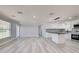 Open-concept living space with kitchen island and stainless steel appliances and light gray flooring at 165 Cummins Ne Ave, Port Charlotte, FL 33952
