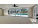 Enclosed carpeted patio showcasing views of the shimmering, screened-in pool at 165 Cummins Ne Ave, Port Charlotte, FL 33952