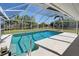 Inviting screened-in pool, providing a private and refreshing outdoor retreat with lush backyard view at 165 Cummins Ne Ave, Port Charlotte, FL 33952