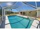 The in-ground pool is in a screened enclosure and is adjacent to a covered patio at 165 Cummins Ne Ave, Port Charlotte, FL 33952