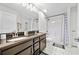 Bathroom with double sink vanity, granite countertop, and shower with patterned curtain at 17 White Marsh Ln, Rotonda West, FL 33947