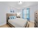 Cozy bedroom featuring a wooden bed frame, light wood floors and a bright window at 17 White Marsh Ln, Rotonda West, FL 33947