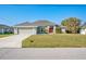 Well-maintained single-story home with a two-car garage and green lawn at 17 White Marsh Ln, Rotonda West, FL 33947