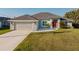 Exterior of the home features a two car garage, well kept lawn and updated front door at 17 White Marsh Ln, Rotonda West, FL 33947