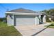 Home exterior features a two car garage, concrete driveway and walkway, as well as manicured lawn at 17 White Marsh Ln, Rotonda West, FL 33947