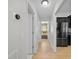 Hallway view of stainless steel refrigerator and bedroom with light wood flooring at 17 White Marsh Ln, Rotonda West, FL 33947