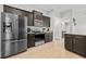 Modern kitchen featuring hardwood floors, stainless steel appliances, granite countertops, and dark cabinets at 17 White Marsh Ln, Rotonda West, FL 33947