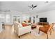 Bright living room with modern furniture, hardwood floors, neutral walls, a ceiling fan, and a back patio view at 17 White Marsh Ln, Rotonda West, FL 33947