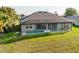 Backyard view of the pool and screened-in patio with table and chairs at 17 White Marsh Ln, Rotonda West, FL 33947